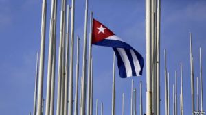 FILE - The Cuban flag flies in front of the U.S. Interests Section in Havana, May 22, 2015.